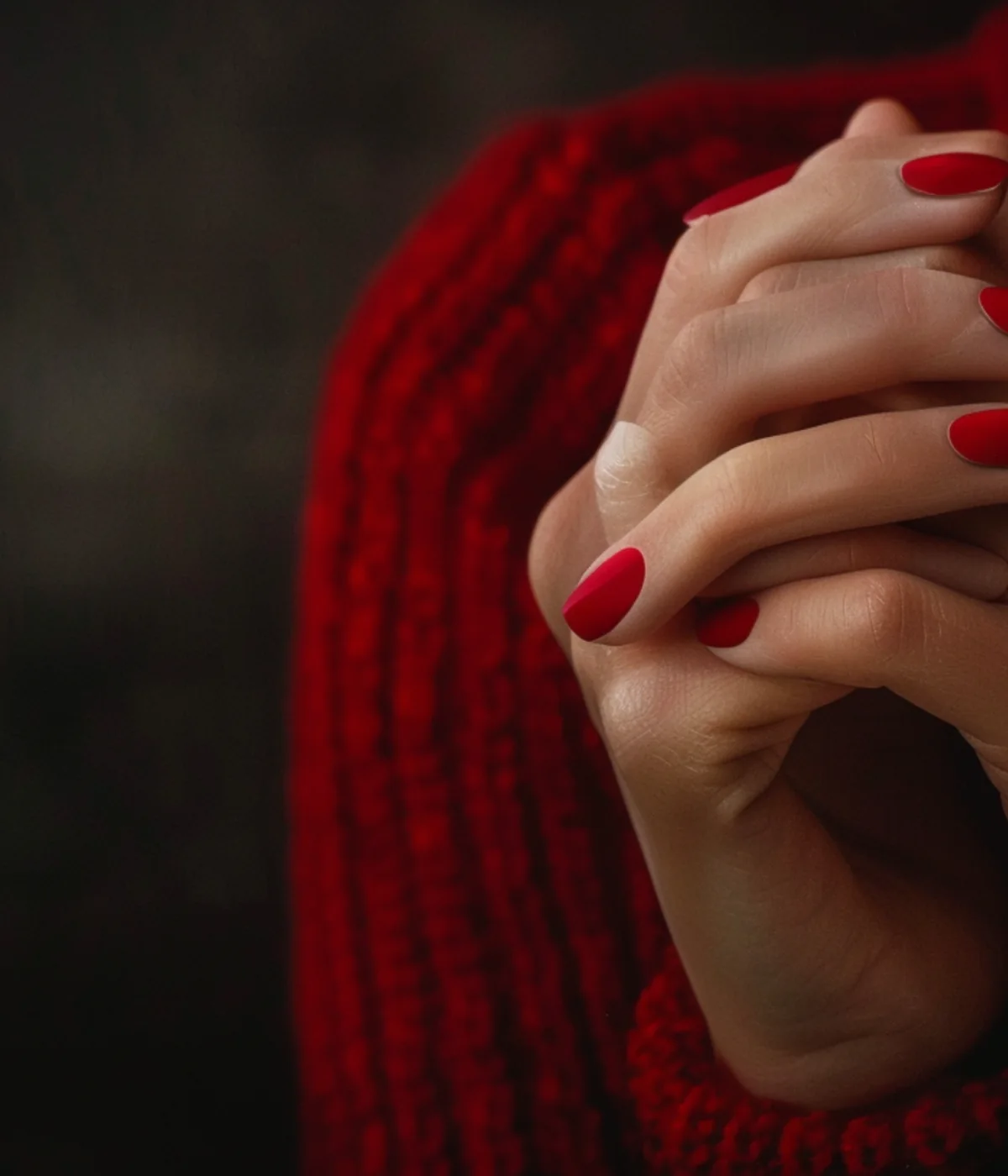 Röd manikyr i varm stickad miljö